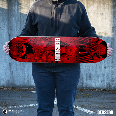 Person holding standard variant red and black skateboard deck with 'Berserk' branding against a concrete wall.